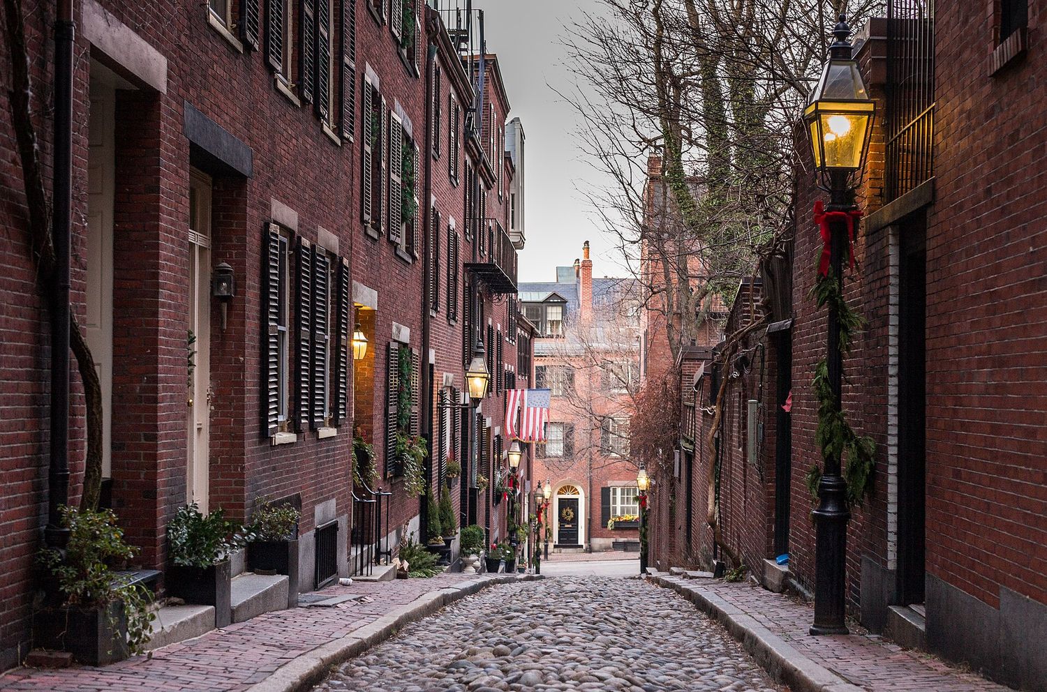Acorn Street in Beacon Hill, a narrow cobbled lane of brick row houses with black shutters, window boxes and gas lamps.