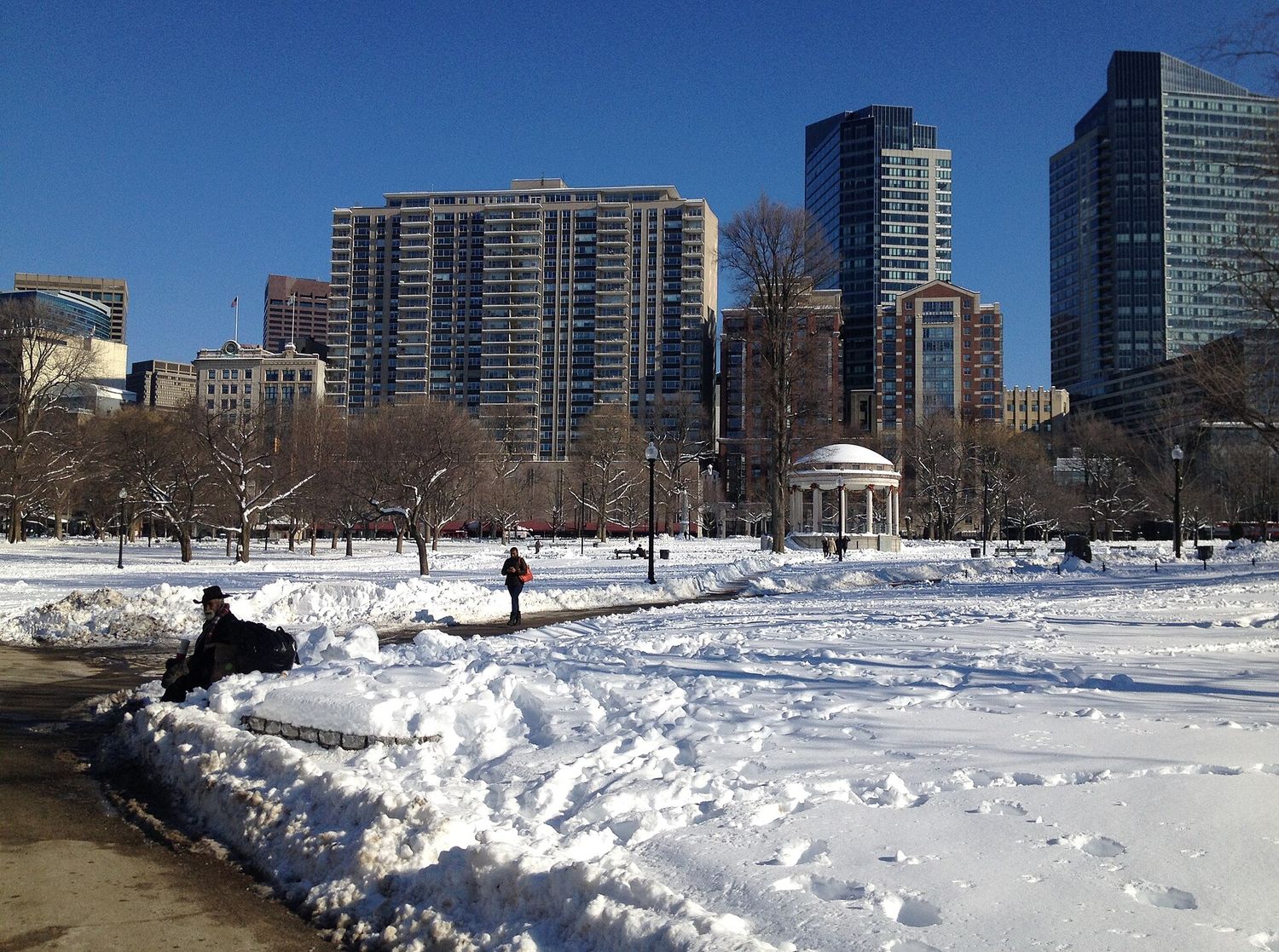Boston Common under snow in winter, with bare trees and footpaths cleared through the drifts.