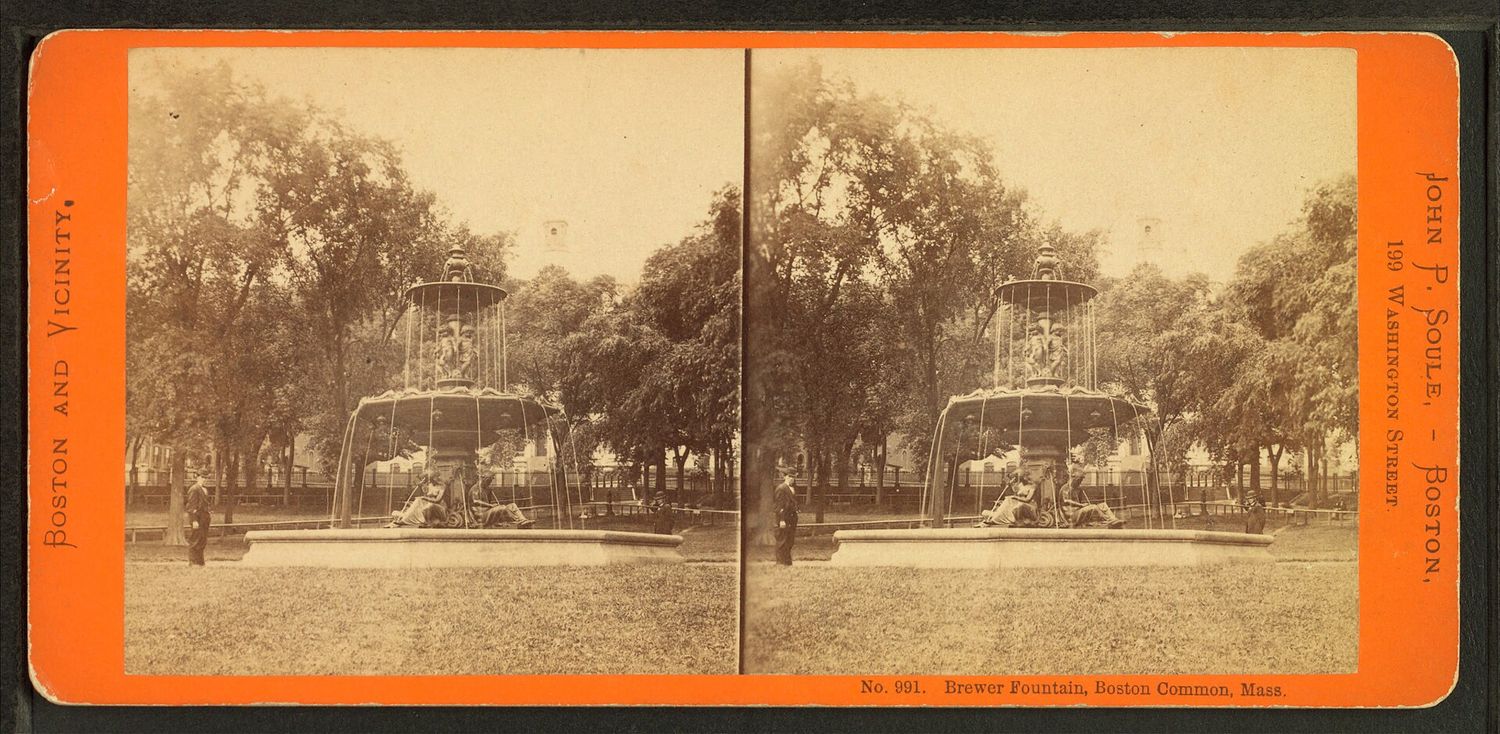 A nineteenth-century stereoscopic photograph card showing the Brewer Fountain on Boston Common, with water falling from its two tiers and bronze figures seated around its base, trees behind and two men standing nearby.
