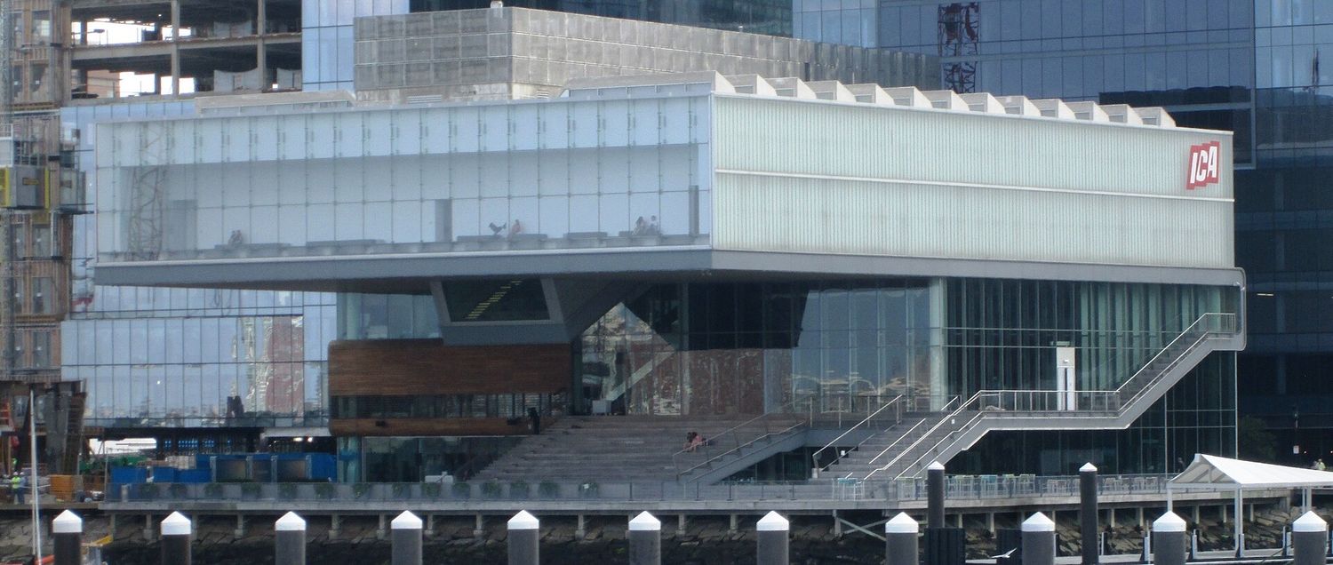 The Institute of Contemporary Art in Boston seen from the harbor, its upper gallery box cantilevered out over the waterfront above a glass base and public steps.