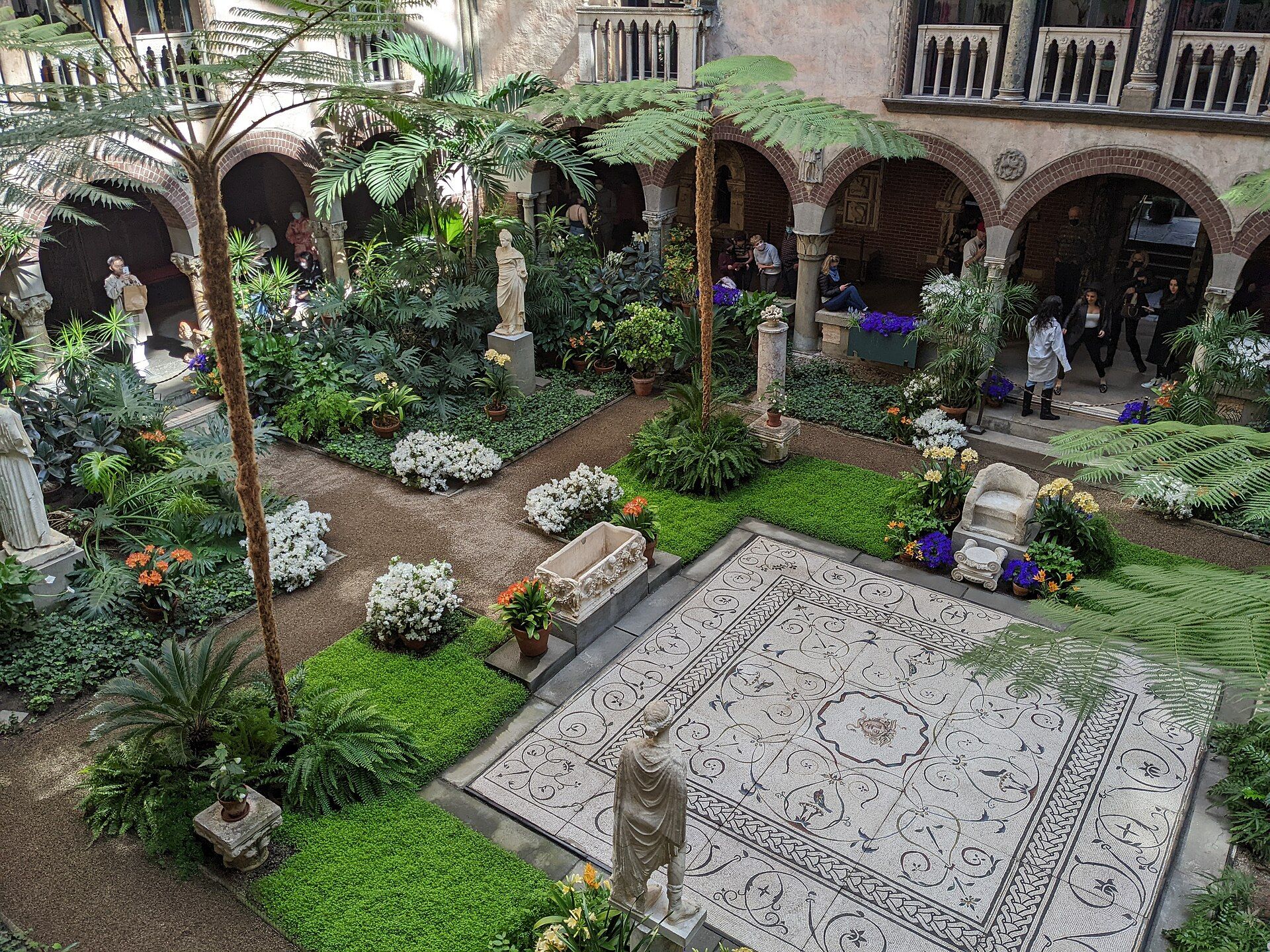 The glass-roofed Venetian courtyard at the Isabella Stewart Gardner Museum, filled with ferns, palms and Roman statuary.