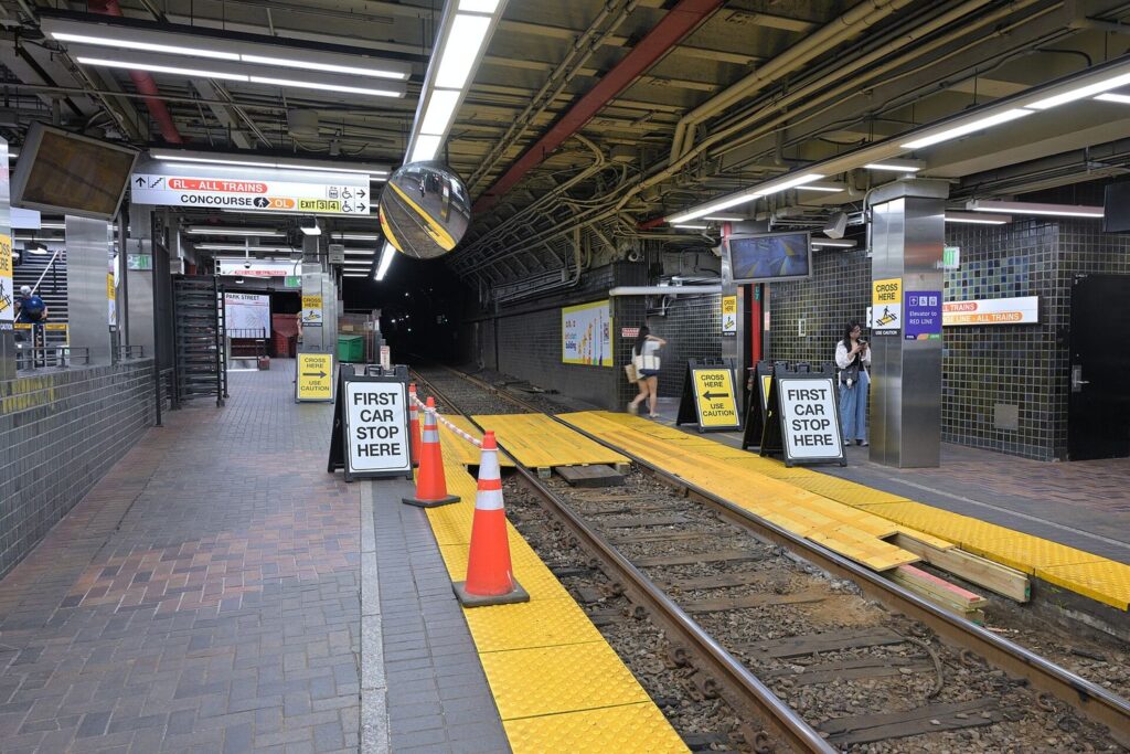 A Green Line platform at Park Street station in Boston with overhead signs to the Red Line.